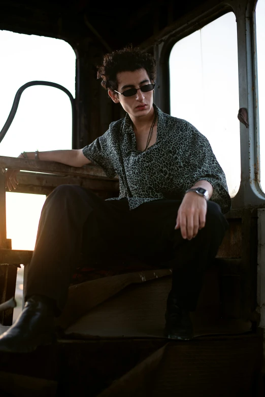 man sitting on the steps of an old looking train car