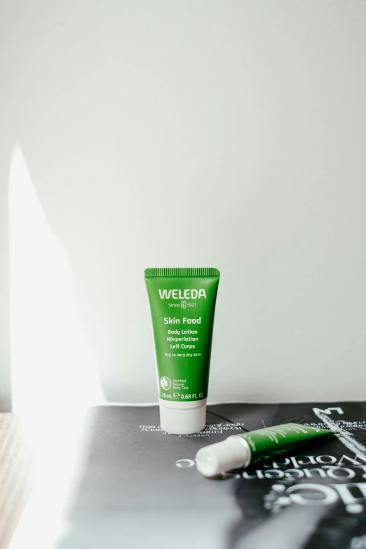 an empty tube of the weleda natural face and lip scrub sitting on top of a magazine
