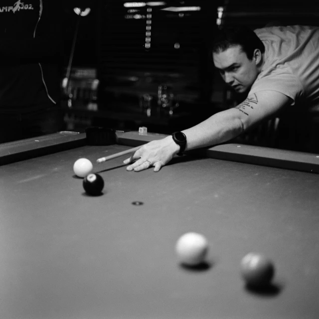 a man is holding the edge of a pool table