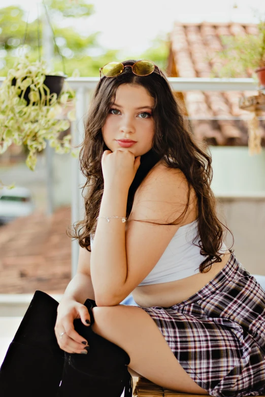 a young woman with long hair is sitting and posing for the camera