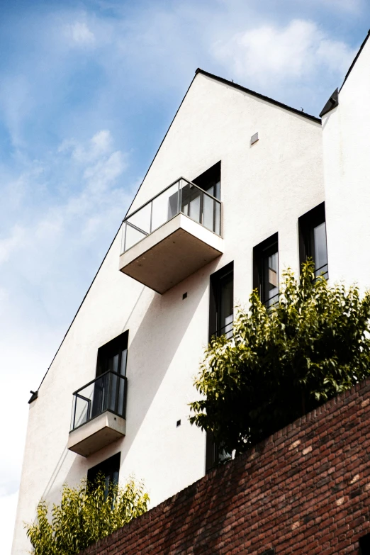 a white building with balconies is sitting under a blue sky