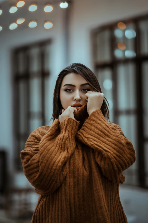 a girl standing in front of a building talking on her phone