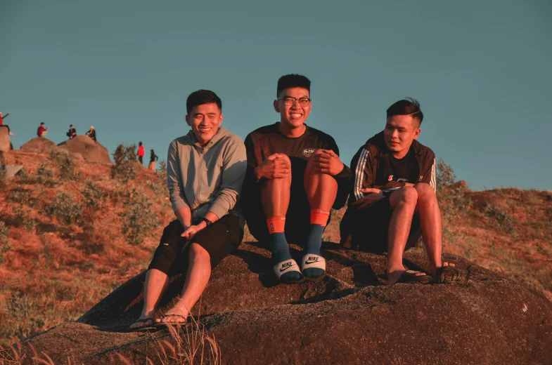 three boys sitting on an elephant while wearing sports socks