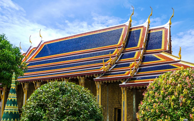 a beautiful blue - and - yellow building is covered with leaves