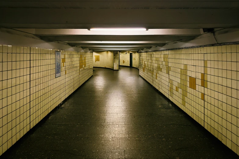 a walkway with yellow tiled walls leading up to the doors