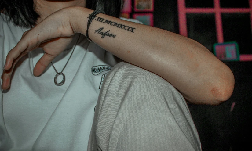 a tattooed arm holding onto someone's wrist
