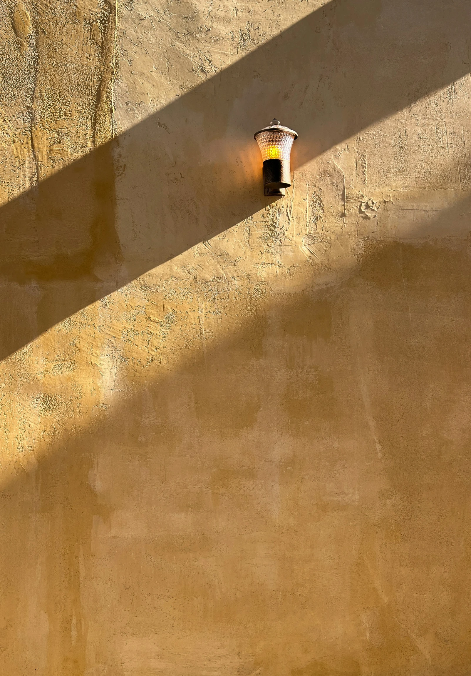 a street light on a building with shadows