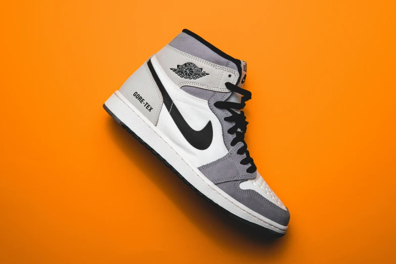 a pair of nike sneakers on an orange background