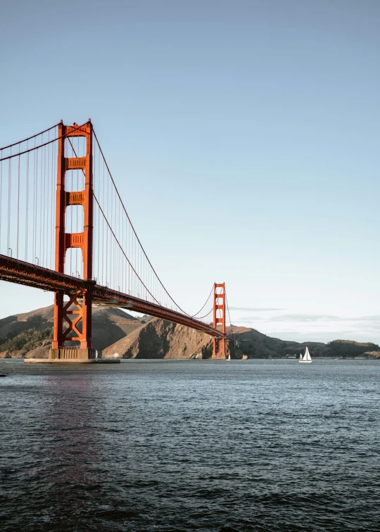 the golden gate bridge and sailboat are seen in the distance