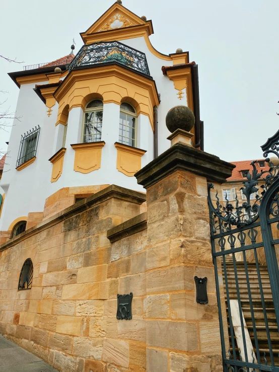 an iron gate stands against a old building