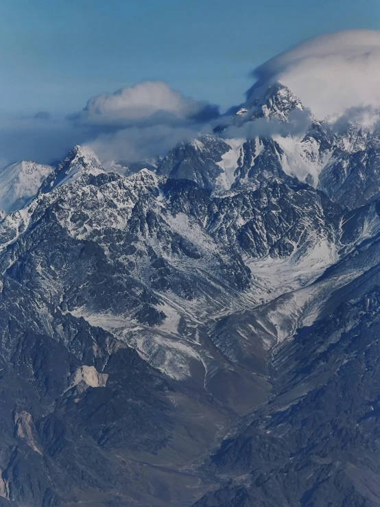 the mountain range is covered with snow and clouds