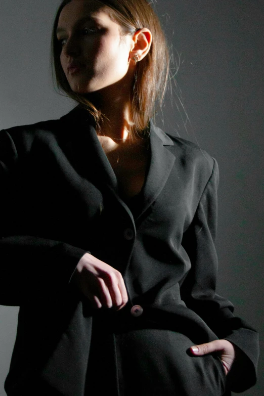 the woman is posing in her black coat