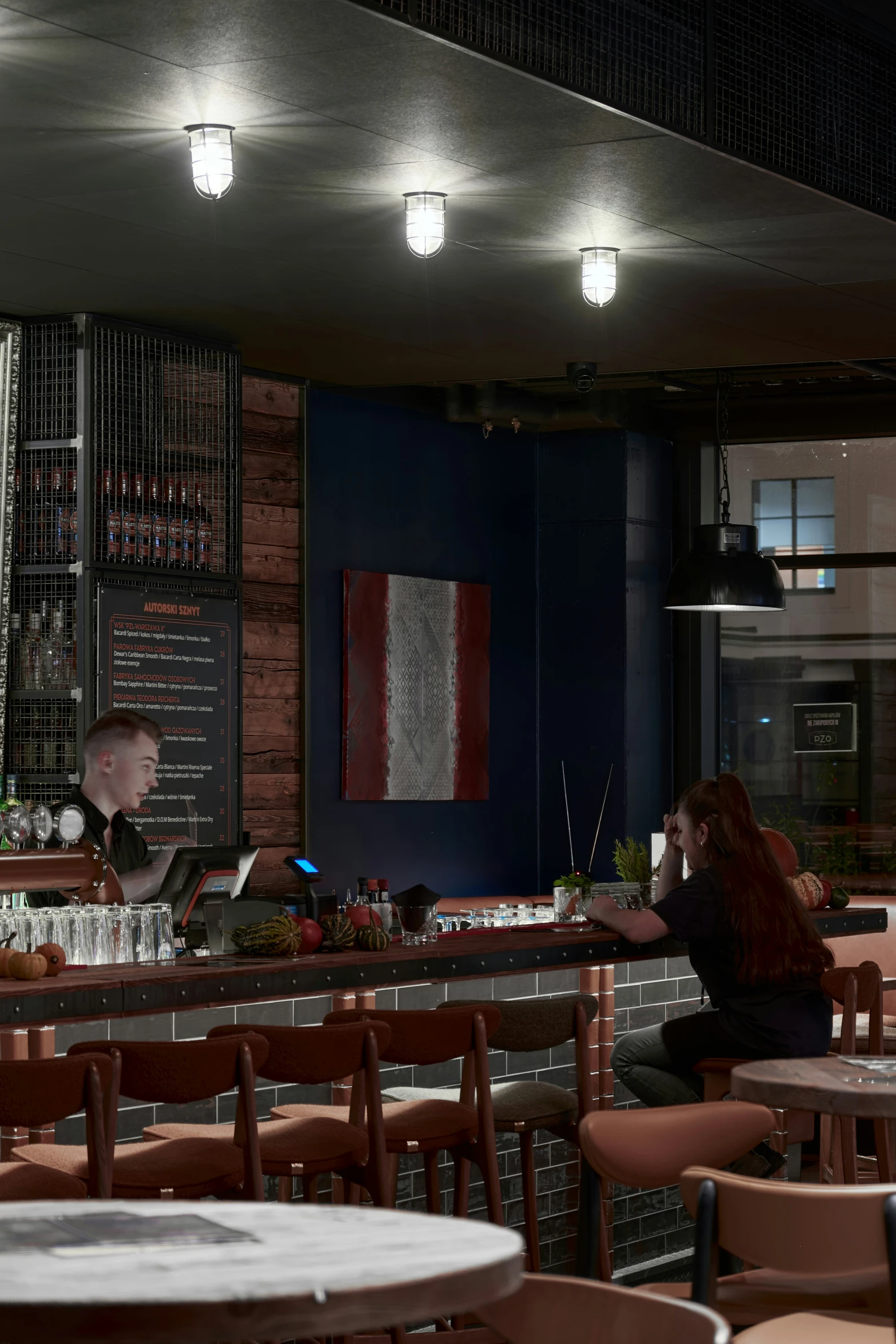 a woman sits at a restaurant and looks back into the distance