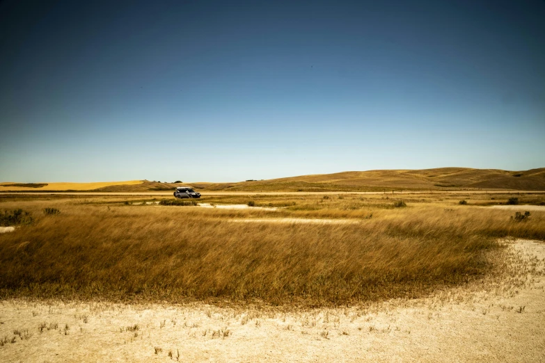 a small truck traveling across an open field