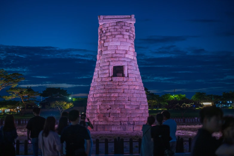 a group of people standing around in front of a tower