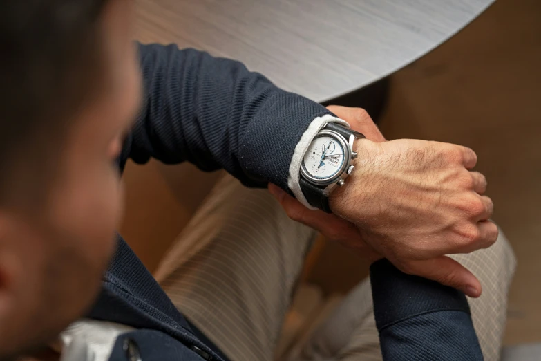 a man wearing a watch sitting on a chair