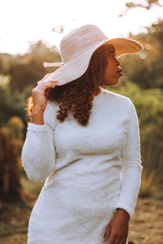 the woman is wearing a hat and a white dress