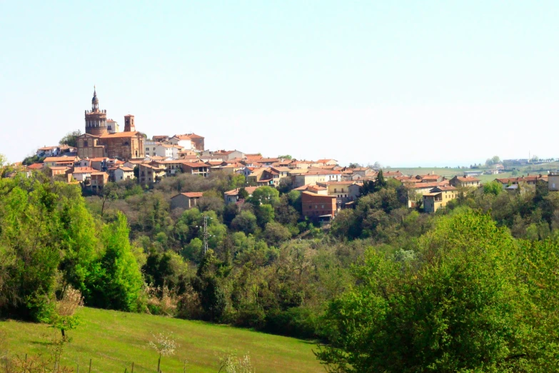 a rural countryside with trees and buildings on top of it