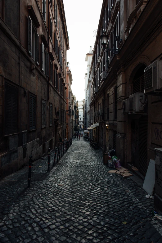 a narrow cobblestone street in a large city