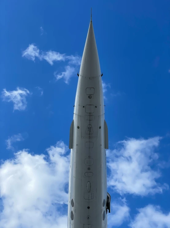 the jet is flying in the blue sky with white clouds