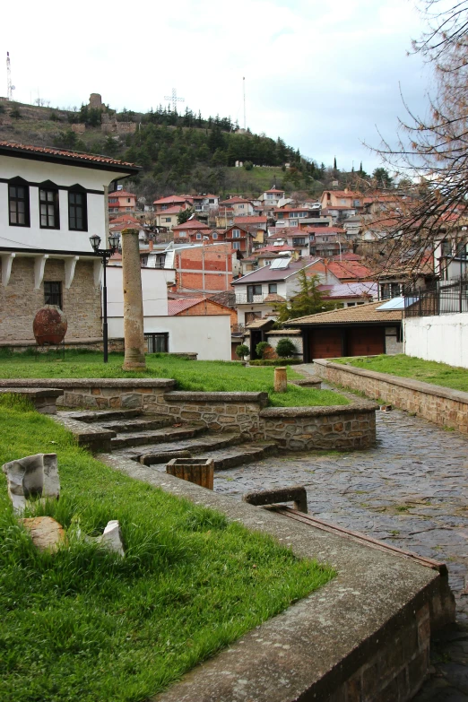 there is a stone fire hydrant and buildings in the background