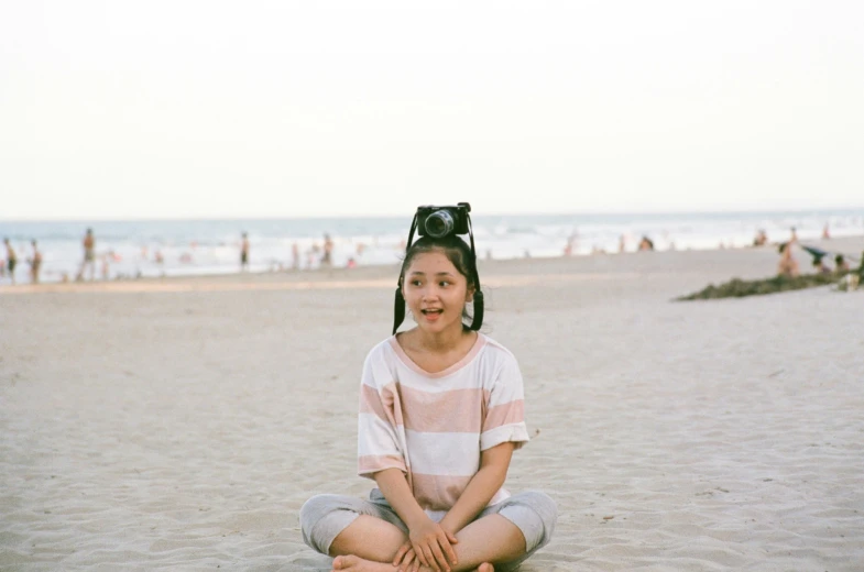 there is a girl sitting on the beach