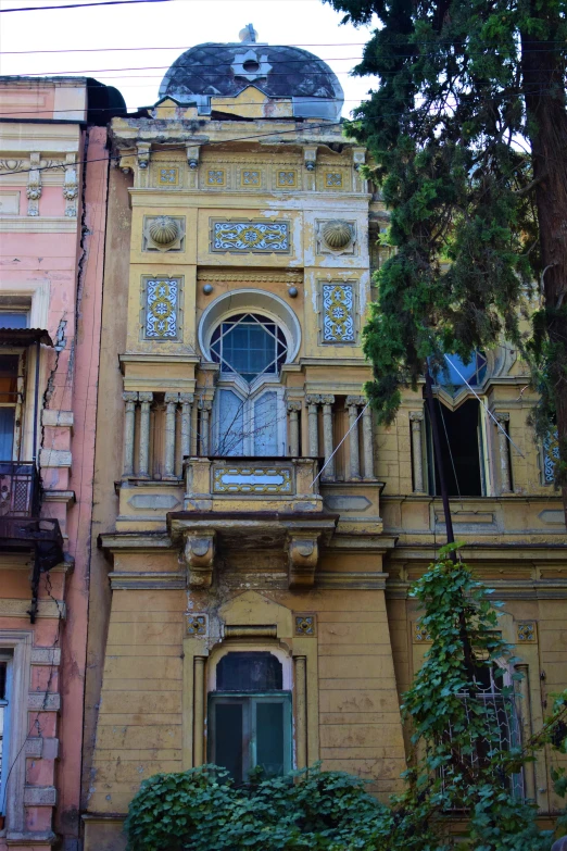 an old yellow building with balcony, balconies, and windows