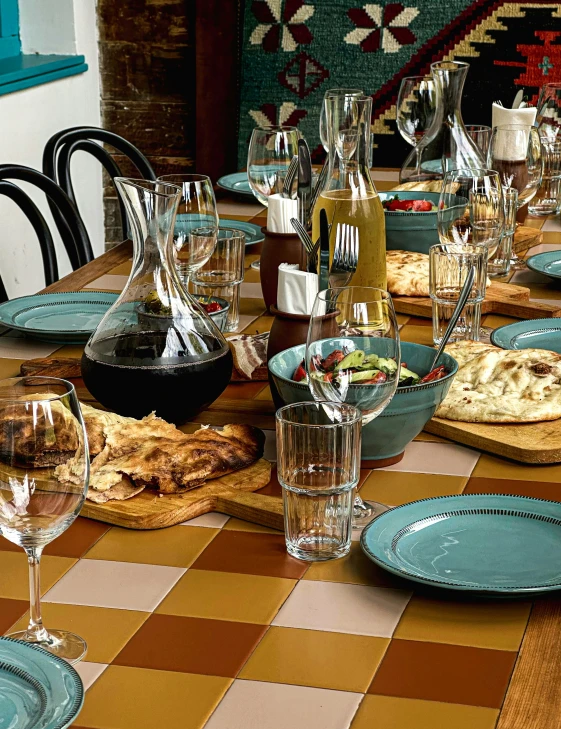 a dining table with dishes and wine glasses on it