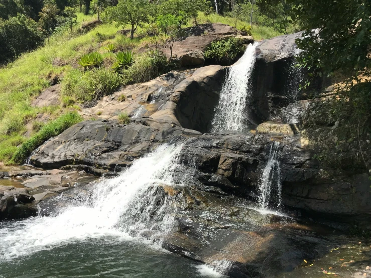 a waterfall cascading down into a lake surrounded by rocks