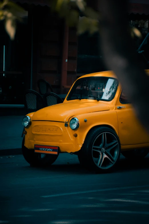 a small yellow car parked on the side of the road