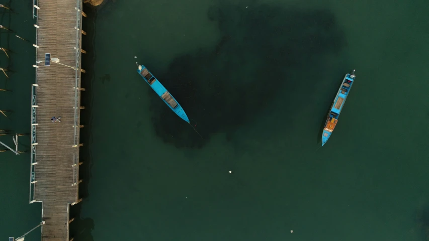 several blue boats in the water next to a dock