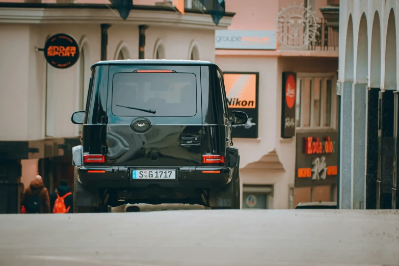 black jeep parked on street with multiple pedestrians