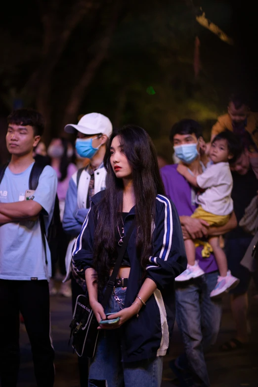 several people stand together outside wearing face masks