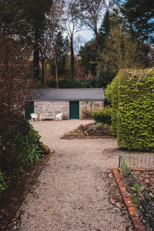 a gravel path that leads into a small garden