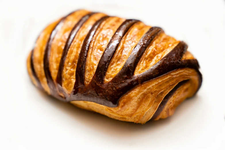 a chocolate pastry is sitting on a white surface