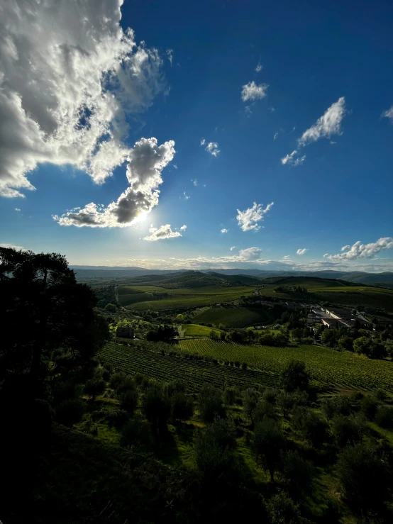 the sun shines over the rolling hills below