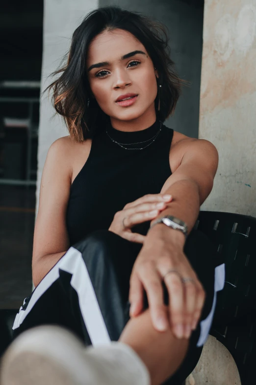 a woman is sitting on a bench wearing a tank top