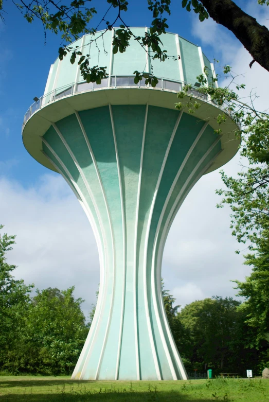 a very tall green building with a glass tower at the top