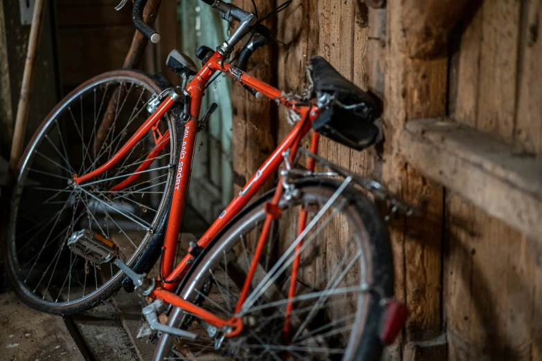 a red bicycle parked next to a wooden building