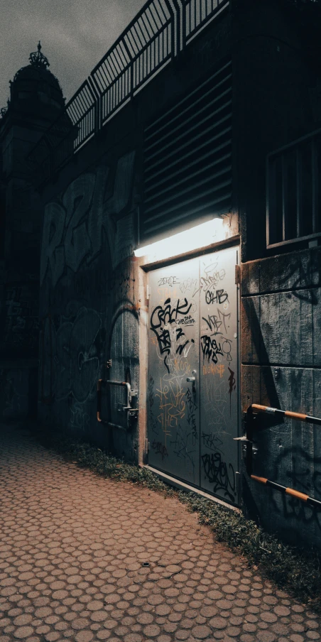 graffiti on a door of a building next to a brick street