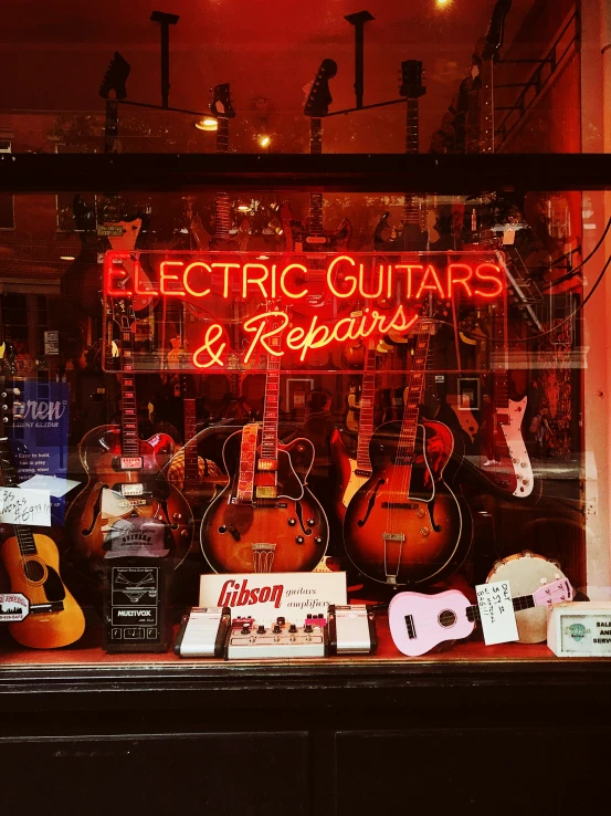 electric guitars and repair signs are set up in the front window