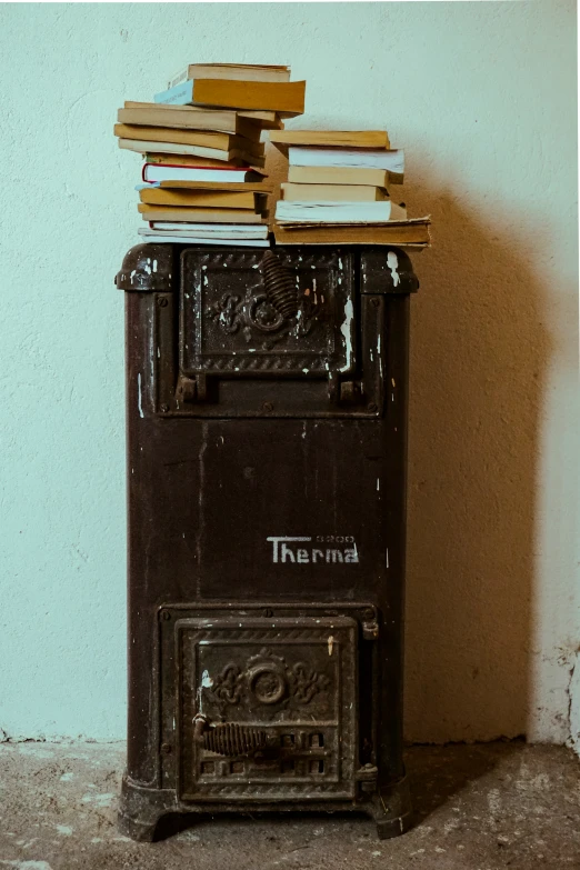 there is an old fashioned type of stove with many books on top