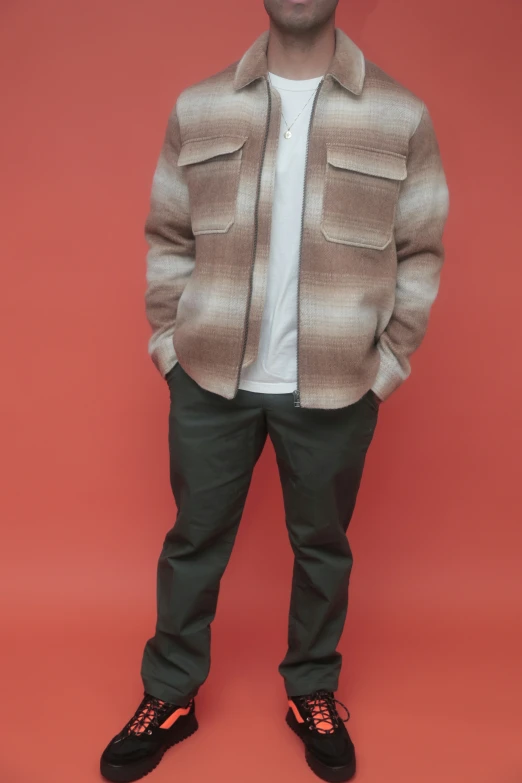 a man is posing for the camera with his jacket and sneakers