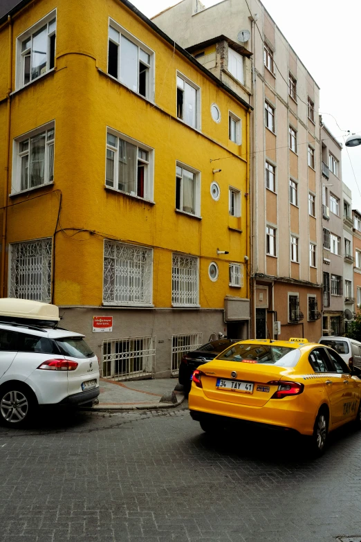 several cars parked on the street next to buildings