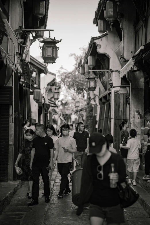 the young men are walking through a narrow city street