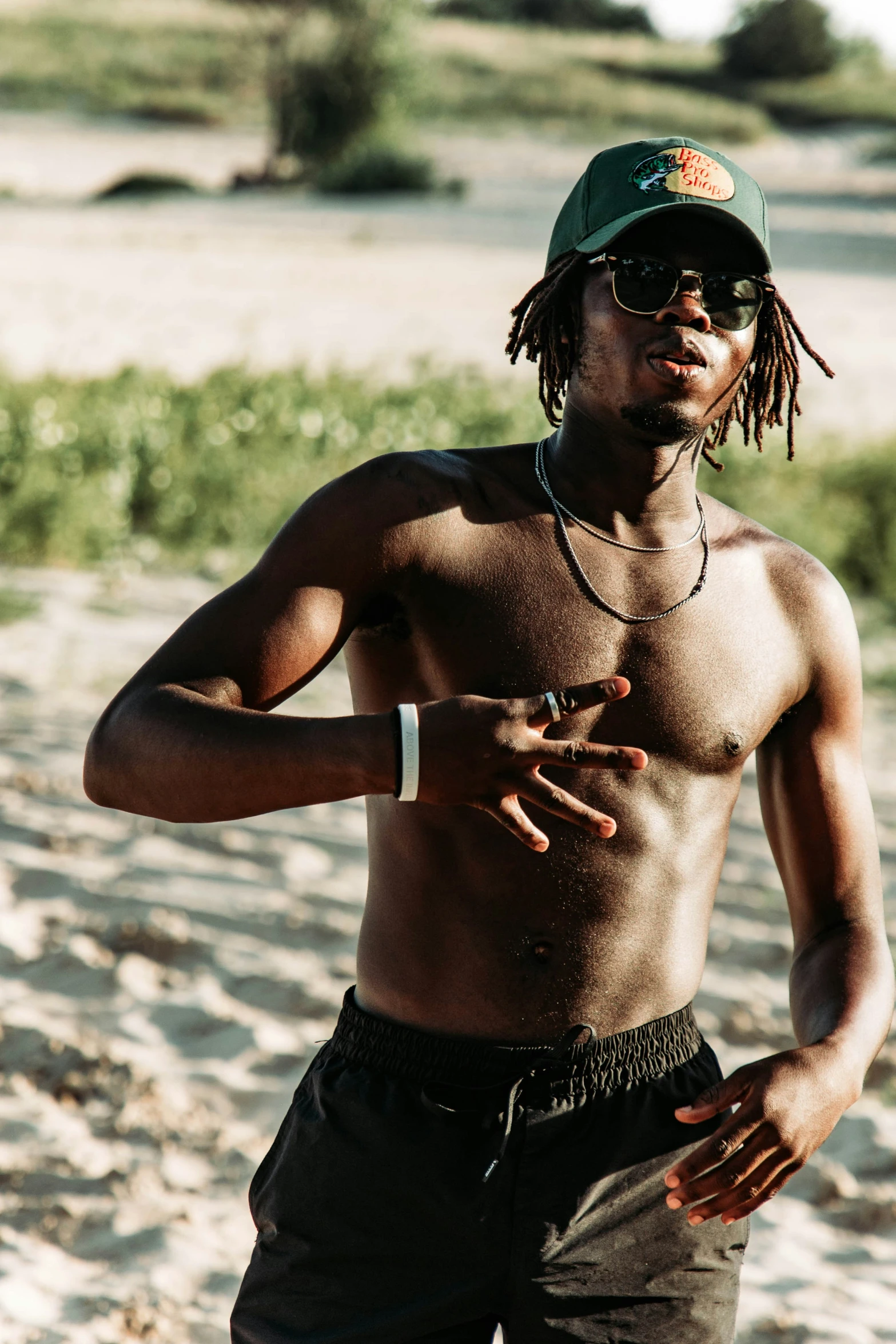 a man in shorts and baseball cap on a beach