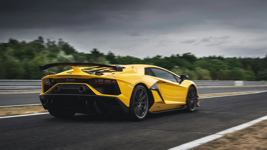 a yellow sports car drives along the highway