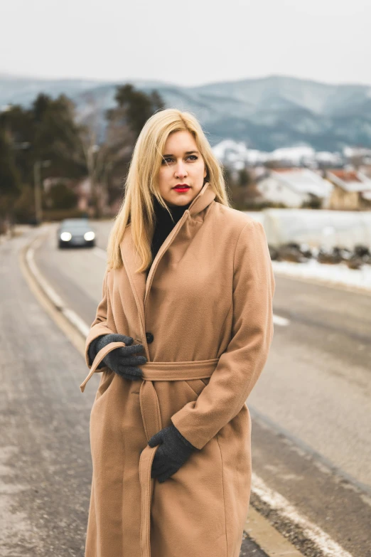 a woman with long hair and red lips stands on a road