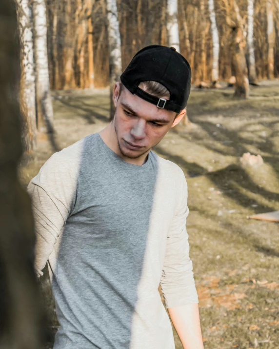 a man that is in the woods with a baseball hat on