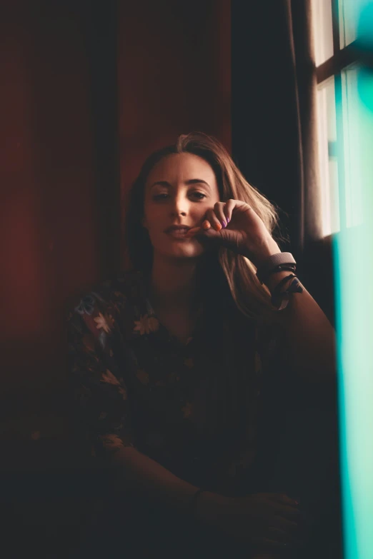 woman sitting at window with a cigarette in her hand